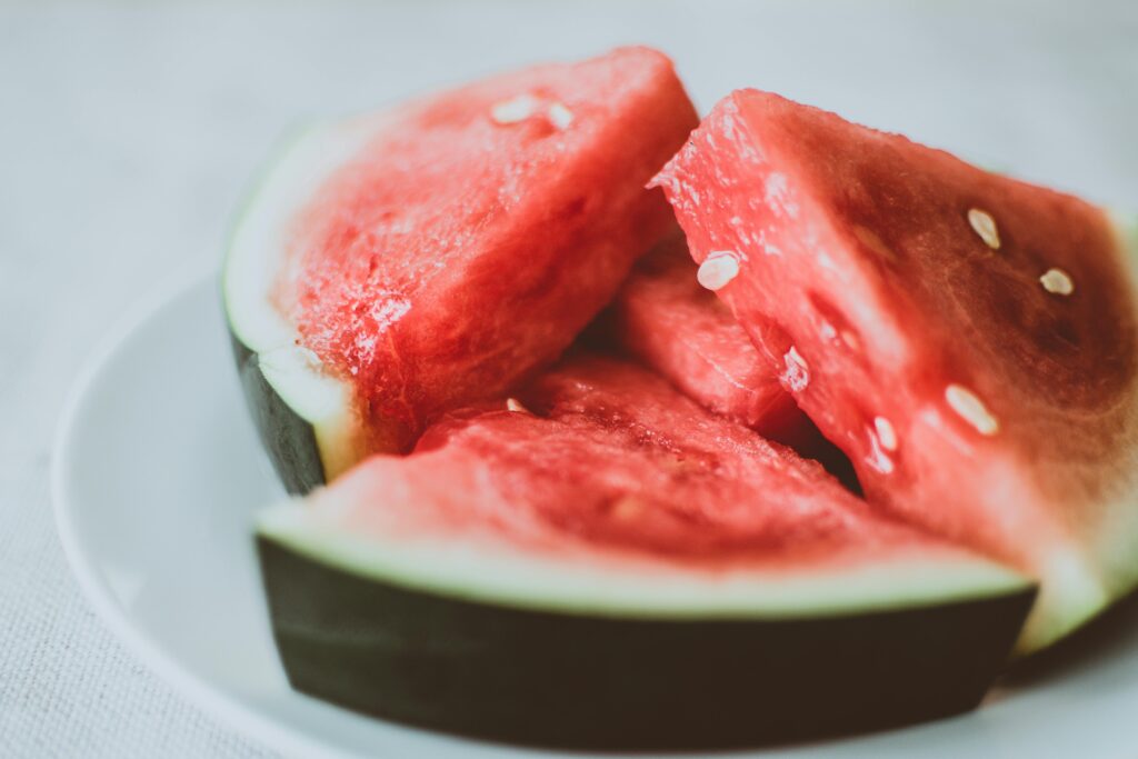 Vibrant and fresh watermelon slices with seeds on a plate, perfect for summer refreshment.